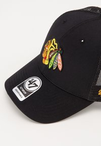 Schwarze Baseballmütze mit Netzrücken, ausgestattet mit einem gestickten mehrfarbigen Logo auf der Vorderseite und einem verstellbaren Riemen. Enthält ein rundes Tag.