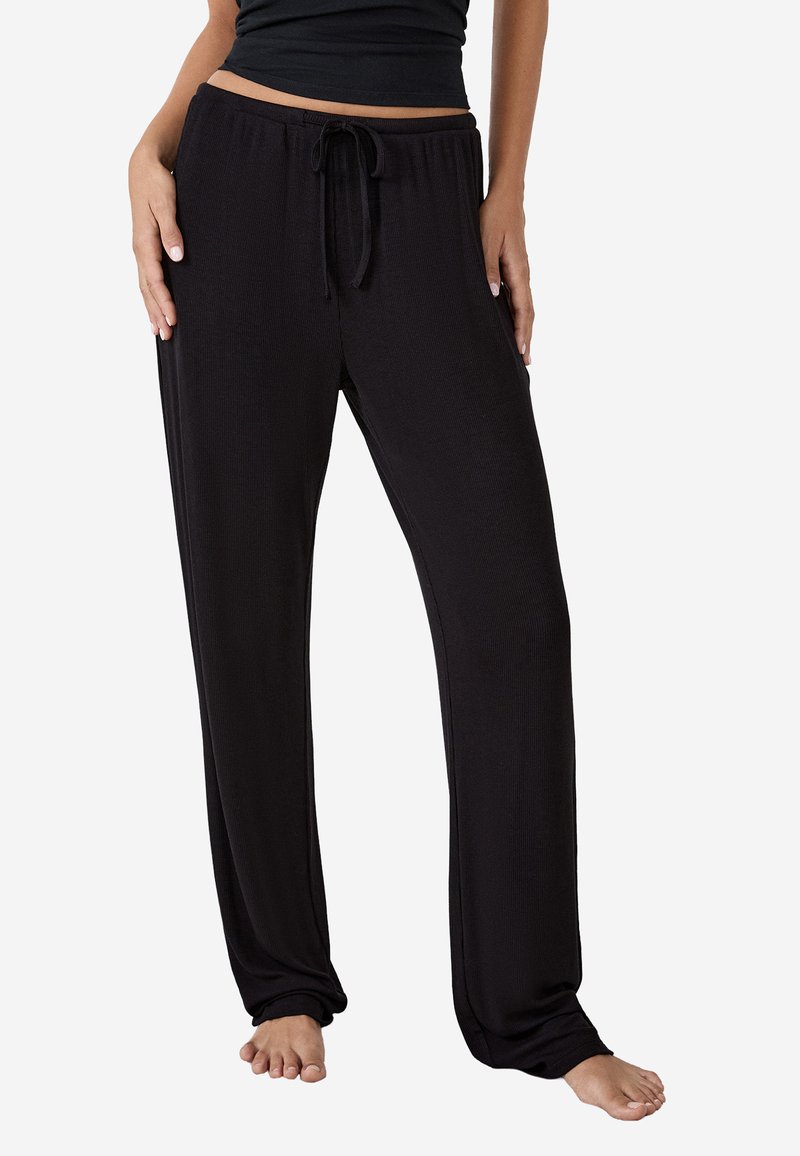Czarne, luźne spodnie dresowe z elastycznym paskiem i sznurkiem. Gładka tekstura, pełna długość i brak widocznych wzorów.