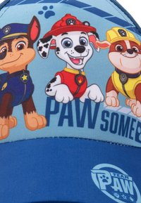 Cappellino da baseball in tessuto blu, con personaggi di cani dei cartoni animati e la scritta "PAW". Il design include dettagli colorati e motivi giocosi.