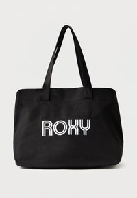 Melna somiņa ar Roxy logo izteiksmīgos baltos burtiem. Tai ir divi rokturi un taisnstūra forma ar gludu auduma tekstūru.