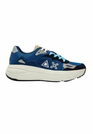 Sneaker blu e navy con tomaia in suede e mesh, dettagli bianchi, suola intermedia bianca spessa e suola esterna in gomma nera testurizzata.