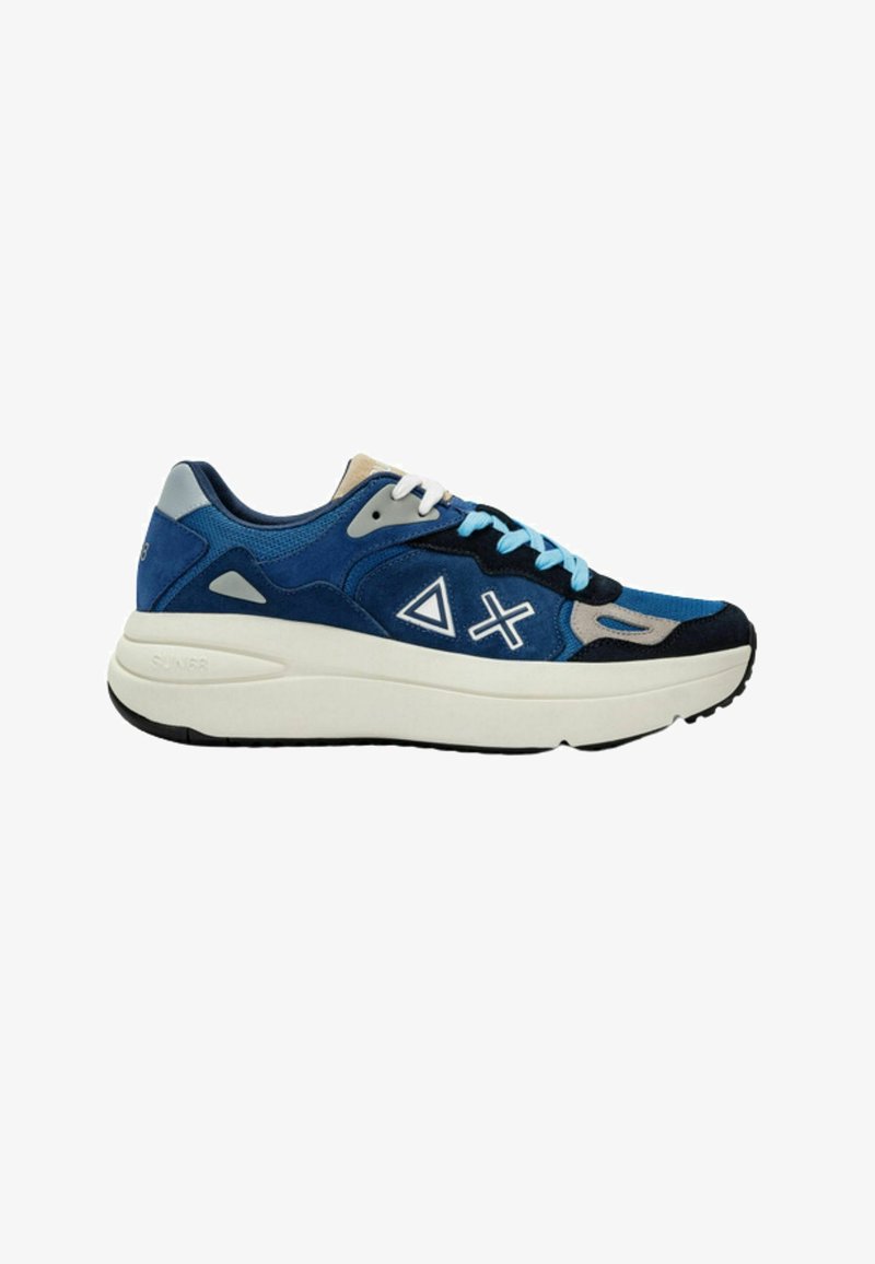 Sneaker blu e navy con tomaia in suede e mesh, dettagli bianchi, suola intermedia bianca spessa e suola esterna in gomma nera testurizzata.