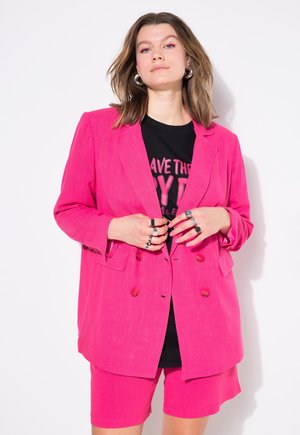 Blazer double boutonné en lin rose avec des shorts assortis. Les caractéristiques notables incluent de grands boutons, des poches à rabat et une coupe décontractée.