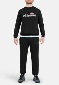 Zwarte sweatshirt met het "ellesse" logo in grijs en oranje, gecombineerd met bijpassende zwarte broek. Voorzien van ribgebreide boorden en zoom, en een getextureerde stof.