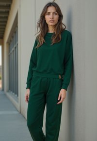 Zöld sportos öltöny, puha anyagból készült. Hosszú ujjú pulóverből és a derékon gumis jogger nadrágból áll.