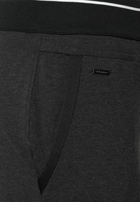 Svarta bomullsjoggers med en texturerad väv, med en sidoficka, elastisk midja och en diskret logotagg på fickan.