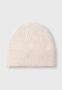 Bonnet en tricot en tissu crème doux. Présente un motif en côtes verticales et un revers replié avec un accent de marque subtil. Apparence texturée et chaleureuse.