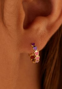 Gouden hoepeloren met hartvormige accenten in roze en paars. Vloeiende afwerking en rond ontwerp, met levendige geëmailleerde kleuren.
