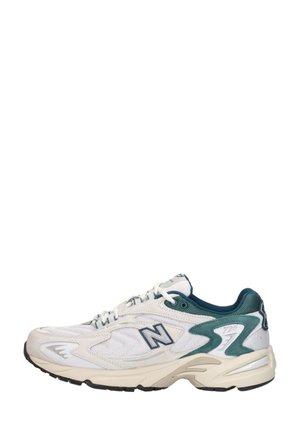 Witte en groene New Balance 725 sneaker met bovenwerk van mesh en suède, dikke gevoerde zool en zwarte rubberen buitenzool, zijaanzicht.