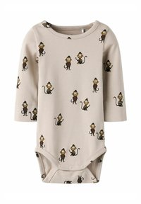 Body beige à manches longues en tissu doux, arborant un imprimé de singes ludiques dans différentes poses, avec une fermeture pressionnée au bas.