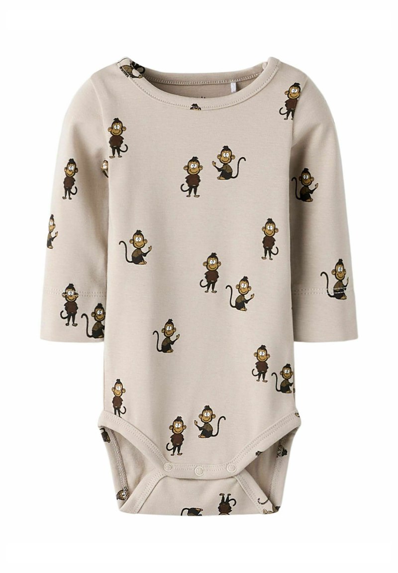 Body beige à manches longues en tissu doux, arborant un imprimé de singes ludiques dans différentes poses, avec une fermeture pressionnée au bas.