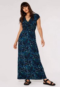 Maxikleid in Dunkelblau mit grünen Blumenmustern, V-Ausschnitt und gerafftem Oberteil; kombiniert mit schwarzen Sandalen.