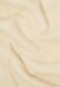 Kremo spalvos audinys su švelniu, lygiu paviršiumi, su subtiliais raštais ir švelniais raukšlėmis, rodančiomis lengvą ir lanksčią konstrukciją.