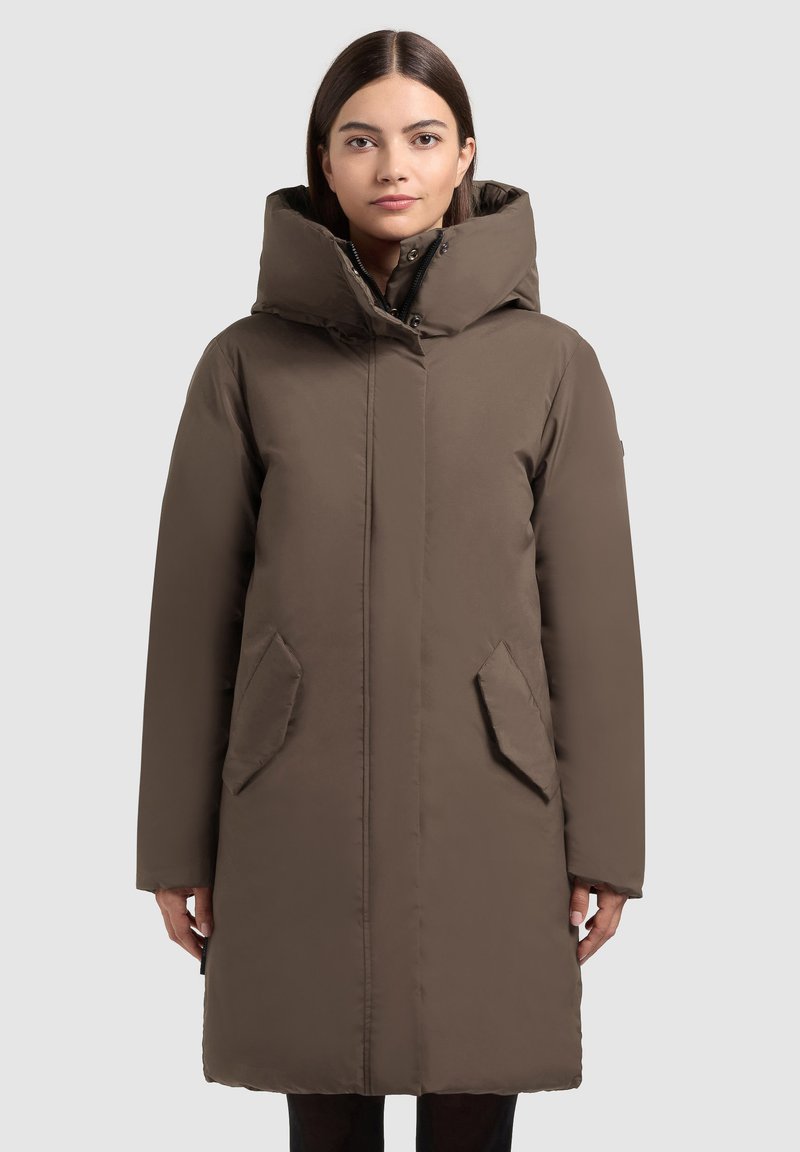 Bruine geïsoleerde winterjas met een hoge kraag, rits aan de voorkant en zijzakken, met een gladde textuur en knie-lengte ontwerp.