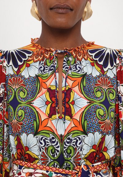 Colorful floral-patterned dress with ruffled neckline, featuring orange, blue, and green hues. Includes a keyhole opening and a matching belt.