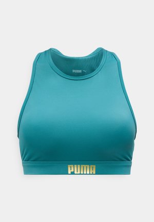 Groenblauwe sportbeha met hoge hals, brede bandjes en goudkleurig "PUMA"-logo op de onderband, weergegeven tegen een effen lichte achtergrond.