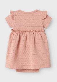 Robe en coton rose avec des manches courtes, des accents froncés, un motif de pois texturé et une taille élastique. Comprend un body intégré.