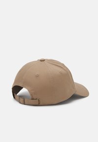 Beige bomull baseball cap med buet skygge, justerbar stropp bak og seks-panel design med ventilasjonsperforeringer.