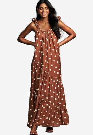 Abito maxi marrone a pois con spalline arricciate e gonna a più strati. Realizzato in tessuto dalla trama liscia.