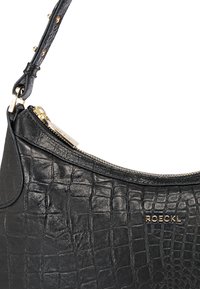 Sac à épaule en cuir noir avec une texture crocodile, fermeture éclair dorée et accent de logo doré. Bandoulière ajustable avec des clous décoratifs.