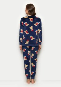 Set di pigiama blu navy in morbido pile, con un motivo di orsetti giocosi. La maglia ha una vestibilità comoda e i pantaloni si restringono alle caviglie.