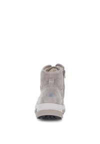Bottines en suède gris avec une fermeture éclair sur le côté, semelle intermédiaire blanche, bout rond et semelle en caoutchouc texturé, avec un logo discret à l'arrière.