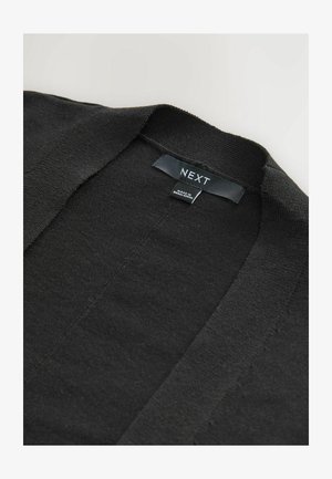 Zwarte gebreide cardigan met een V-hals ontwerp. Zachte textuur, minimale naden en een label met de tekst "NEXT" gestikt bij de hals.