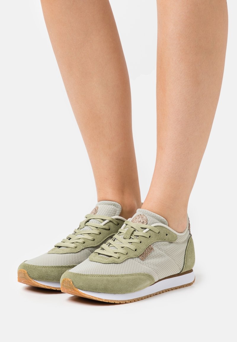 Zelené tenisky s kombinací pletiva a semiše, s texturovaným designem, lehkou konstrukcí a gumovou podrážkou.