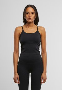 Top fără mâneci de culoare neagră, cu bretele subțiri, design ajustat și decolteu rotund. Fabricat dintr-un material neted și elastic.