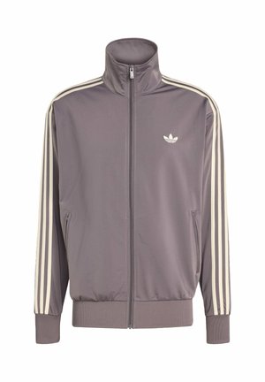 Šedá sportovní bunda s vysokým límcem, plným zipem a elastickými manžetami. Obsahuje bílé pruhy na rukávech a malé logo na hrudi.