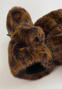 Pantofole in pelliccia sintetica marroni con macchie leopardate scure, caratterizzate da una consistenza morbida e un design aperto sul davanti. Rivestimento interno nero.