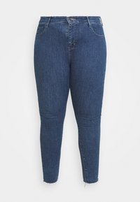 Ciemnoniebieskie wąskie dżinsy wykonane z denimu, z wysokim stanem, pięcioma kieszeniami i delikatnym przetarciem na końcu.