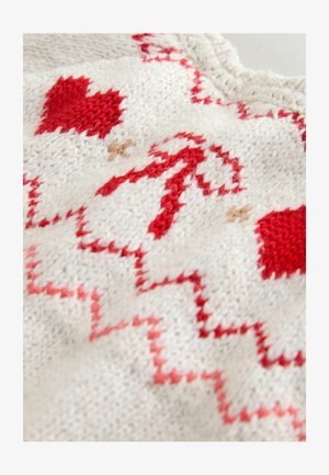 Adīts tekstils ar krēmkrāsas pamatni, uz kuras ir sarkani sirdis un zigzagveida raksti. Mīksta tekstūra ar smalkām detaļām kontrastējošu dzijas krāsu.