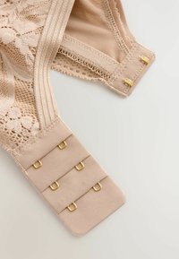 Kailsmeņu bralette bez apakšveļas ar rakstainu detaļu, mīksta auduma, regulējamām siksnām un zeltainiem elementiem aizdarei.
