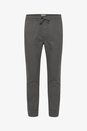 Hallid puuvillased joggerid elastse vöökoha ja nööriga. Omavad kitsenevaid pahkluude osi ja peent tekstuuri ilma nähtavate mustriteta.