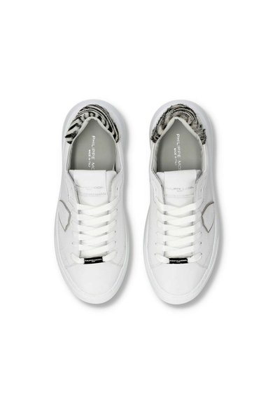Hvide lædersneakers med runde tæer, flade snørebånd og tekstureret sort-hvidt for. Har et diskret logo på tungen.