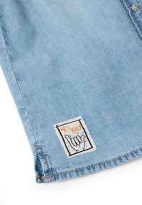 Lichtblauwe denimstof shirt met een klein "YES BRO!" graphic label met een handgebaar. Opvallende stiksels en zoomdetails.