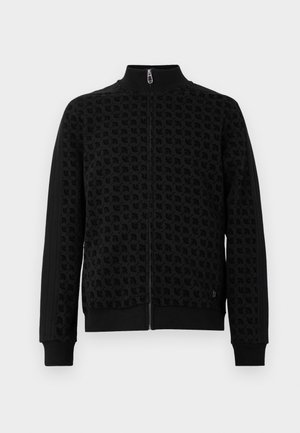 Zwarte zip-up jas met reliëfpatroon, hoge kraag en manchetten. Kenmerkt zijsstrijkaccenten op de mouwen voor extra textuur.