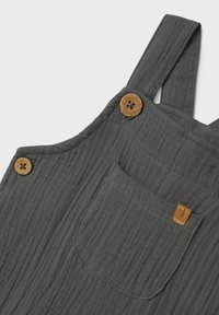 Tensoro grigio in cotone con una finitura testurizzata, caratterizzato da due bottoni marroni e una tasca frontale. Design semplice e funzionale.
