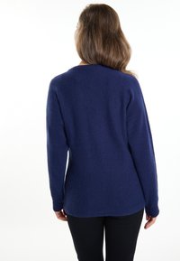 Marineblauer Pullover aus weichem, strukturiertem Stoff mit langen Ärmeln und rundem Halsausschnitt; hinten etwas länger.