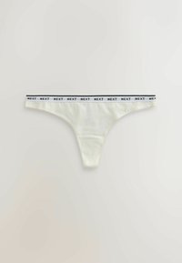 Culotte string en coton blanc avec ceinture élastique comportant le texte noir répété "NEXT" sur fond blanc.