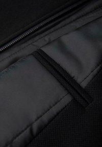 Zwarte stoffen pouch met een ritssluiting, met een gladde textuur en een aparte stoffen strap van binnen voor organisatie.