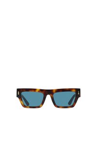 Sluneční brýle v želvovinovém vzoru se výrazným čtvercovým rámem, modrými skly a jemnými zlatými detaily na bocích. Hladký povrch a moderní design.