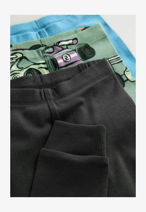 Tre paia di leggings in cotone: quello superiore azzurro chiaro, quello centrale verde con motivo a cartone animato, quello inferiore grigio scuro con polsini a coste.