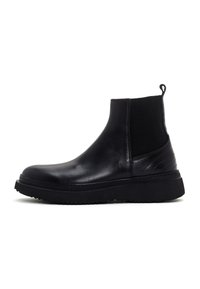 Botte Chelsea en cuir noir avec panneau élastique sur le côté, tirette au talon, bout arrondi et semelle en caoutchouc épaisse.