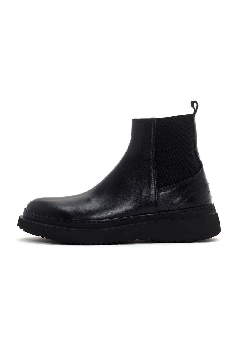 Botte Chelsea en cuir noir avec panneau élastique sur le côté, tirette au talon, bout arrondi et semelle en caoutchouc épaisse.