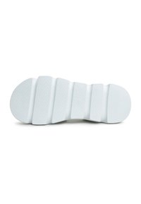 White rubber shoe sole with textured surface, featuring segmented grooves and rounded edges for flexibility and grip.