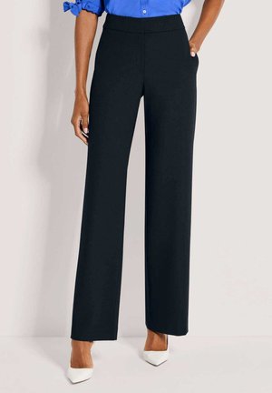 Schwarze, weit geschnittene Hosen mit glatter Textur, hoher Taille und Seitentaschen, kombiniert mit weißen spitzen Absätzen und einer blauen Bluse.