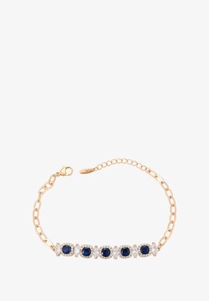Zlatý náramek s alternativními tmavě modrými a čirými drahokamy, s karabinovým zapínáním a nastavitelnými články.