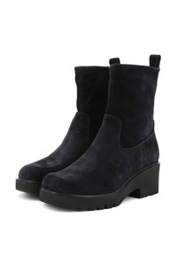 Stivaletti in suede blu navy con suola nera spessa, punta rotonda e pannelli elastici sui lati. Presentano una linguetta per una facile vestibilità.
